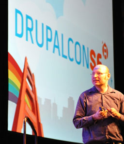 Photo of chx with a large DrupalCon San Francisco logo on the projector screen behind him.